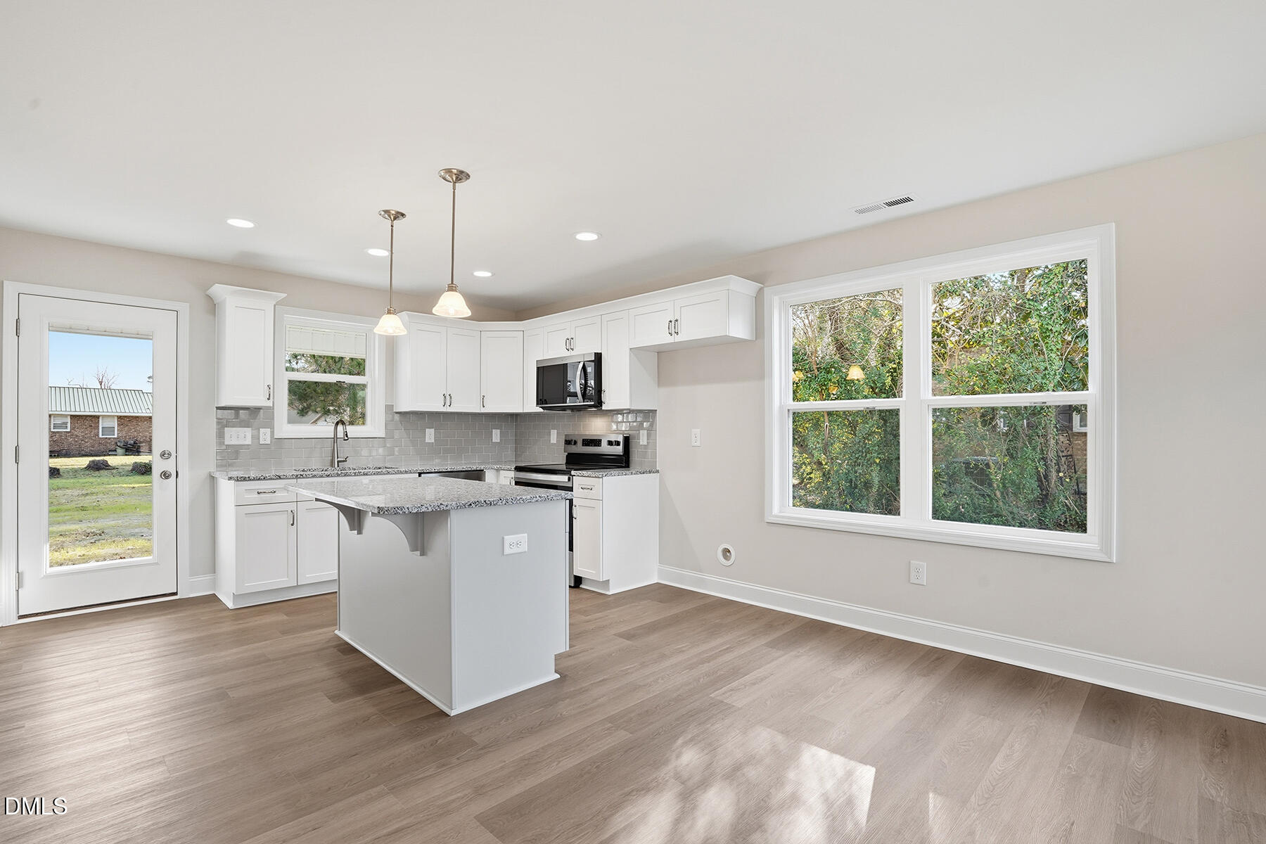 214 Rae Street Warsaw, NC 28398 - Photo 9 of 28 a kitchen with stainless steel appliances granite countertop a refrigerator a sink dishwasher a stove and white countertops with wooden floor