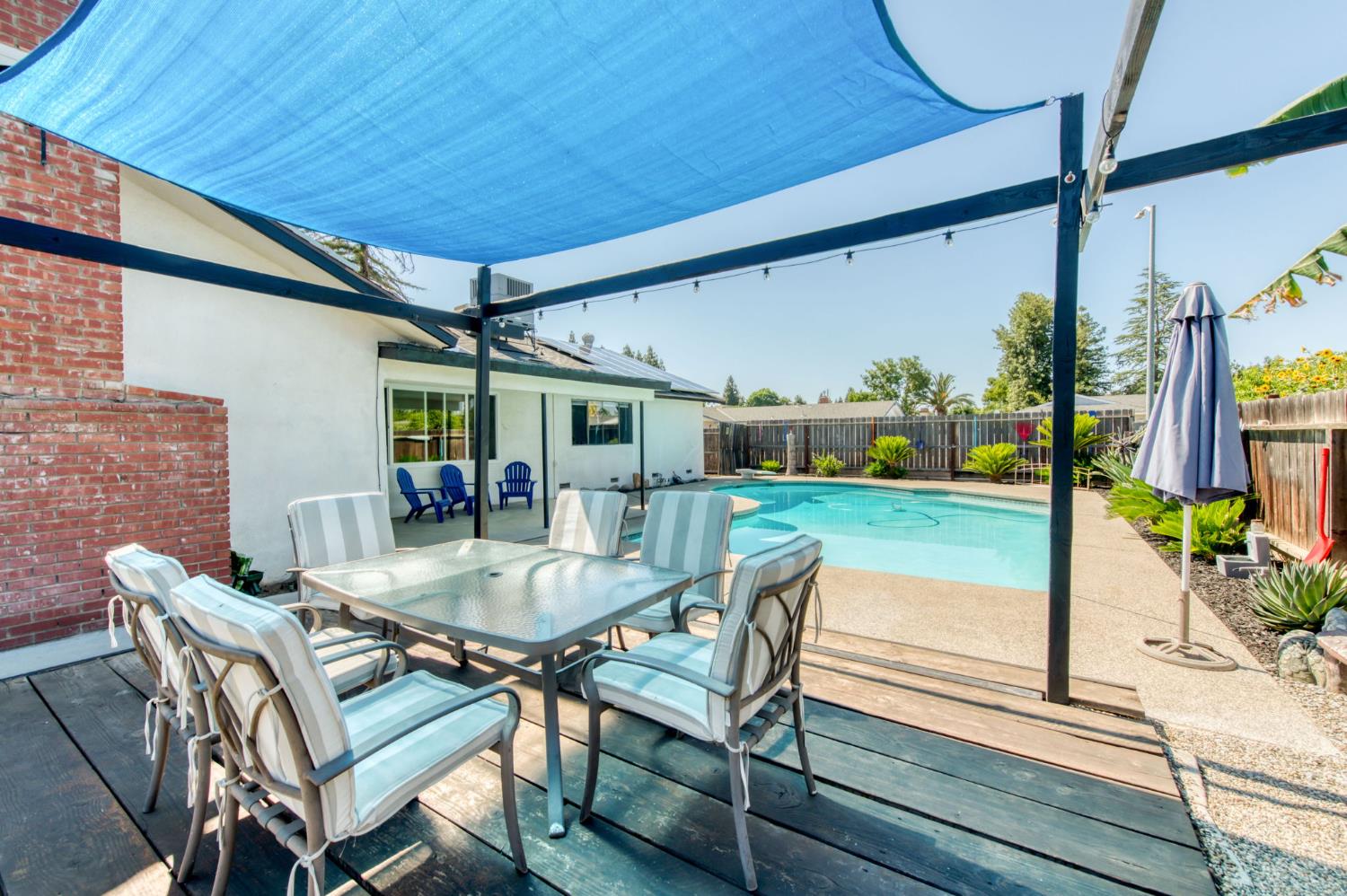 1580 Armstrong Avenue Clovis, CA 93611 - Photo 33 of 50 a view of a patio with table and chairs potted plants with wooden floor and fence