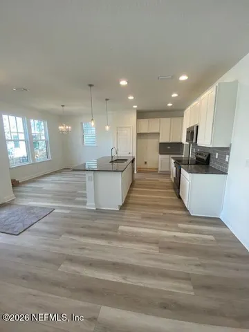 a view of kitchen with kitchen island wooden cabinets and refrigerator