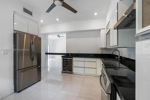 a kitchen with granite countertop a refrigerator and a sink