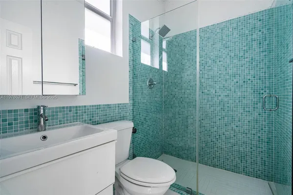 a bathroom with a sink a toilet and shower