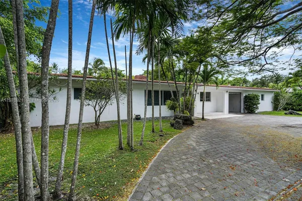 front view of a house with a big yard and potted plants