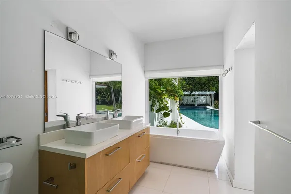 a bathroom with a sink a bathtub and next to a window