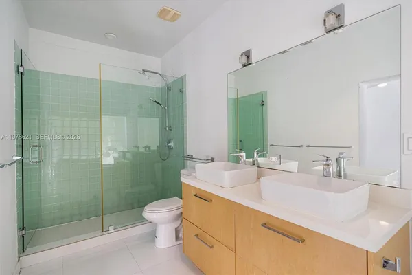 a bathroom with a double vanity sink toilet and shower