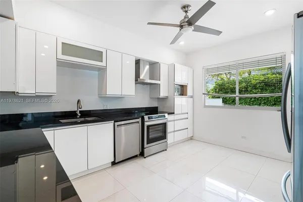 a kitchen with granite countertop a sink stainless steel appliances and cabinets