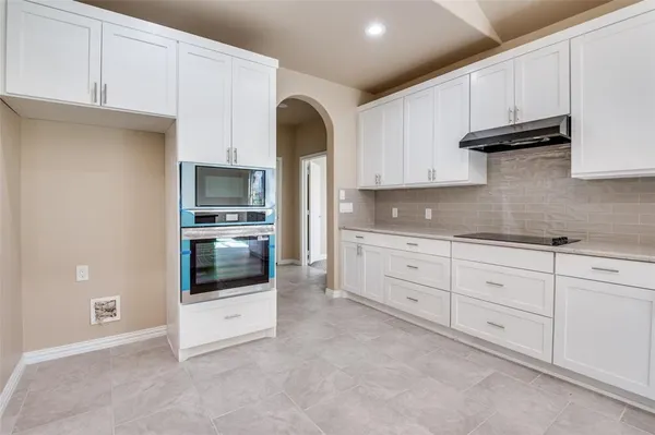 a kitchen with stainless steel appliances granite countertop a stove a sink and a microwave