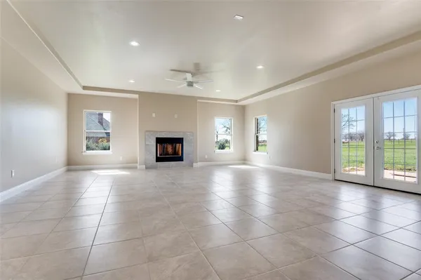 a view of an empty room with a fireplace and a window