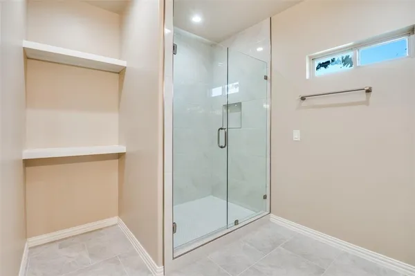 a bathroom with a shower and a glass door