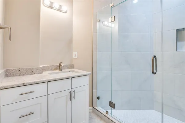 a bathroom with a granite countertop sink a toilet and shower