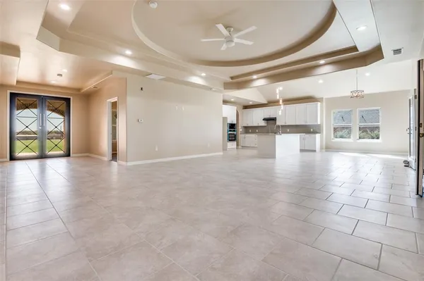 a view of a hallway with chandelier and glass door