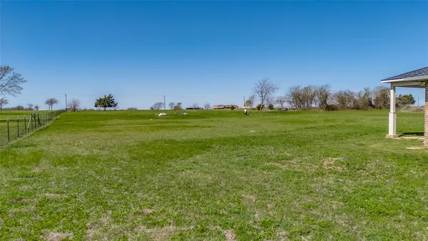 a view of a big yard with a house in the background