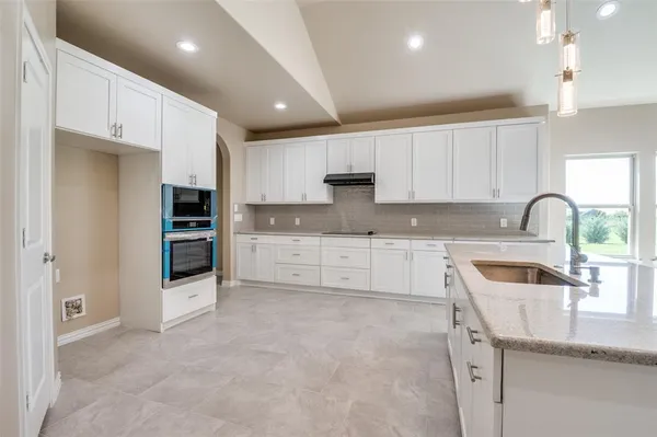 a kitchen with stainless steel appliances granite countertop a sink and a stove top oven