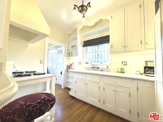 a kitchen with a stove a refrigerator and a dining table with wooden floor