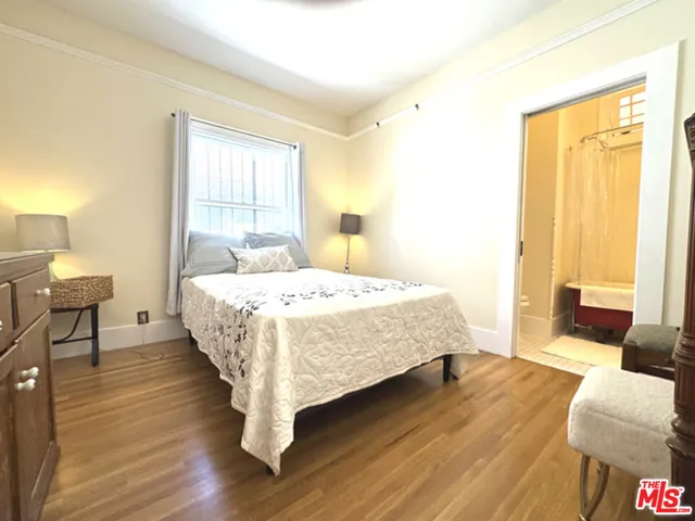 a spacious bedroom with a bed and wooden floor