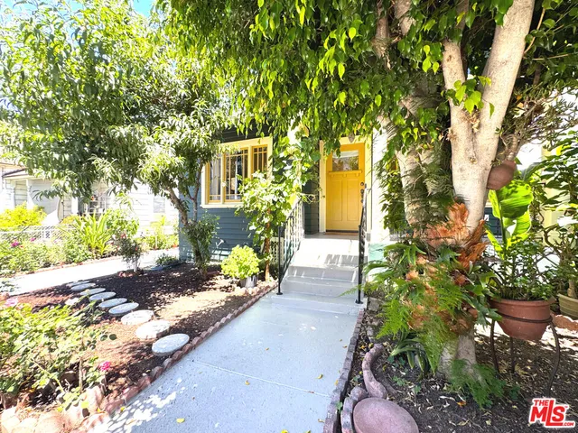 a front view of a house with a yard and fountain in middle