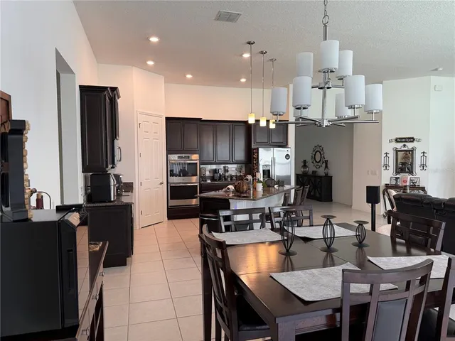 a large kitchen with kitchen island a dining table and chairs