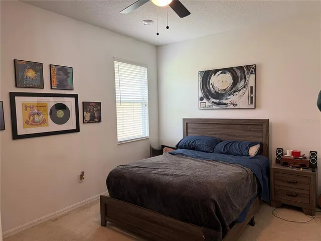 a bedroom with a bed and painting on the wall