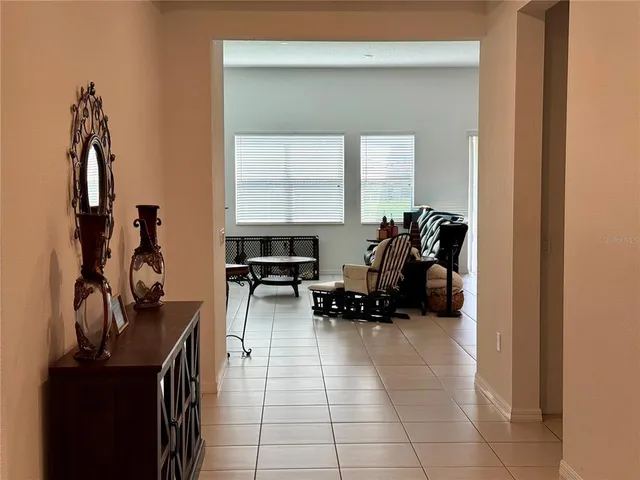 a living room with furniture a computer on the desk and a window