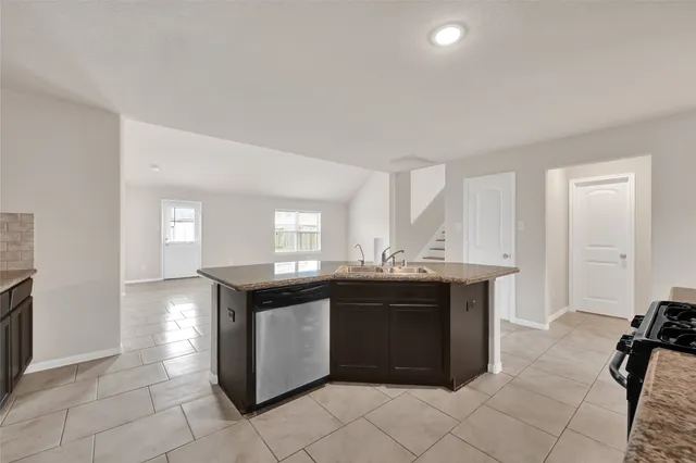 a kitchen with granite countertop a sink and cabinets