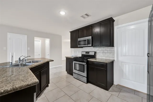 a kitchen with a sink stove and microwave