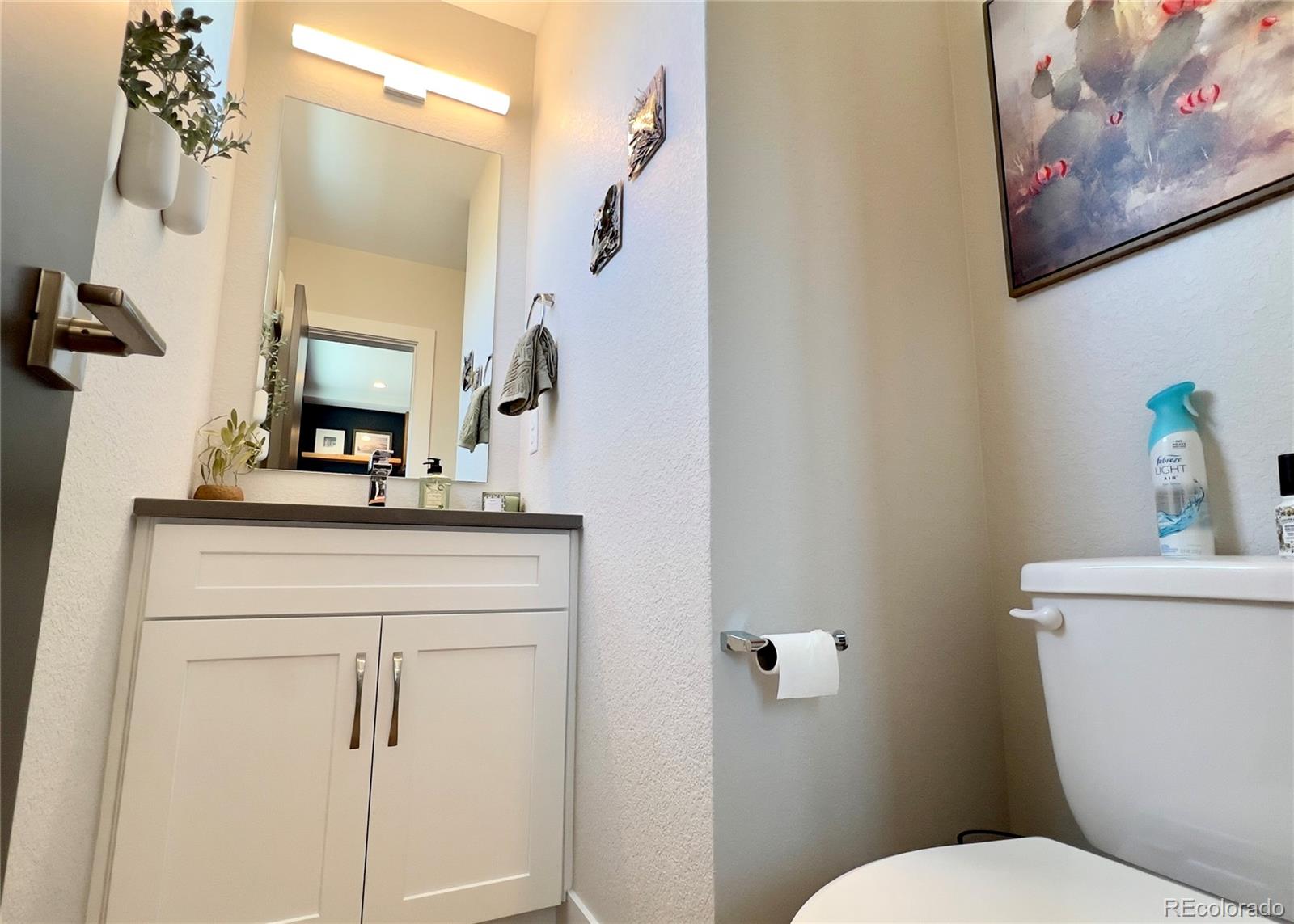 6228 West 38th Avenue Wheat Ridge, CO 80033 - Photo 15 of 38 a bathroom with a toilet a sink and mirror