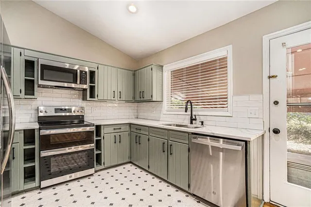 a kitchen with stainless steel appliances a refrigerator sink and stove