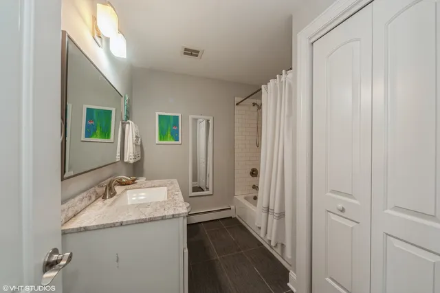 a bathroom with a granite countertop sink and a mirror
