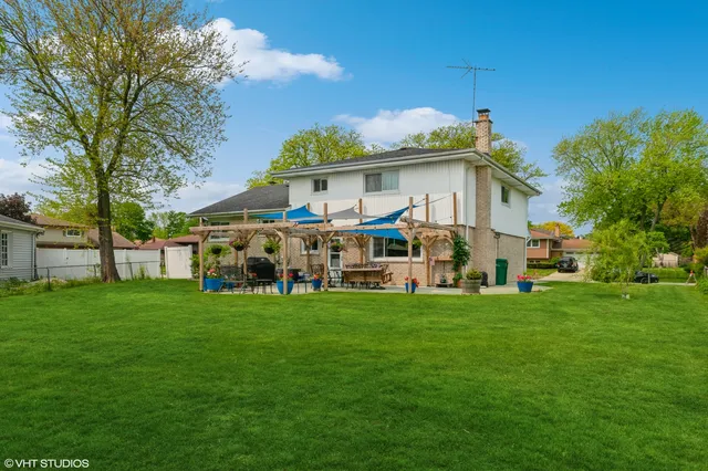 a view of a house with a big yard and large trees