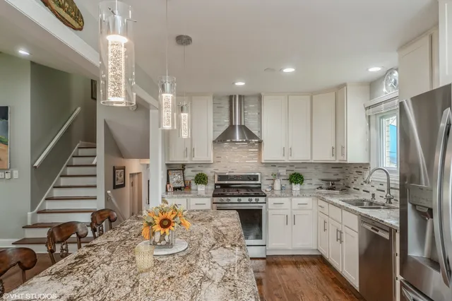 a kitchen with stainless steel appliances granite countertop a refrigerator sink and cabinets