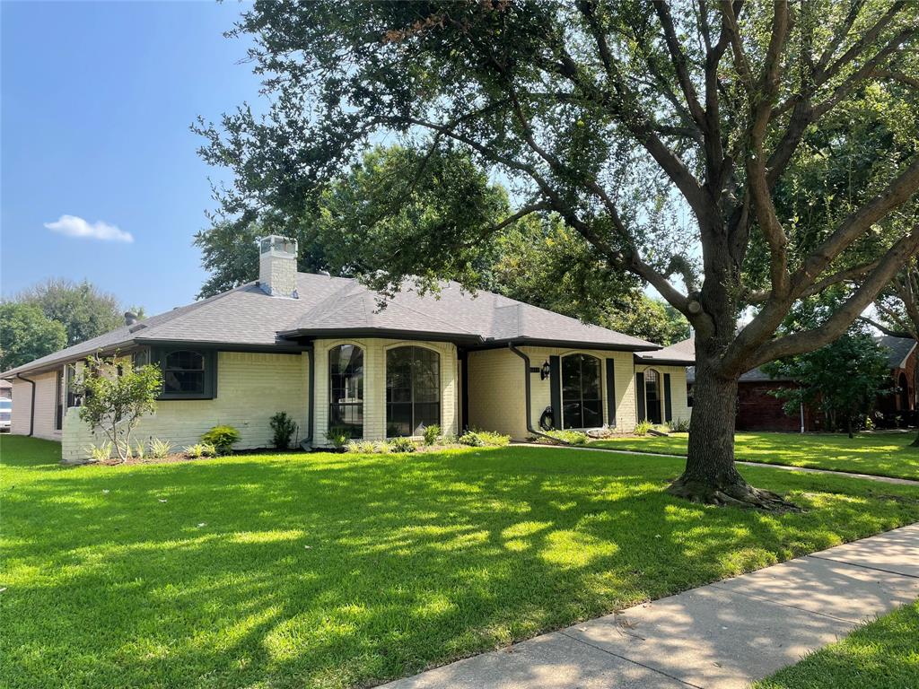 a front view of a house with yard and green space