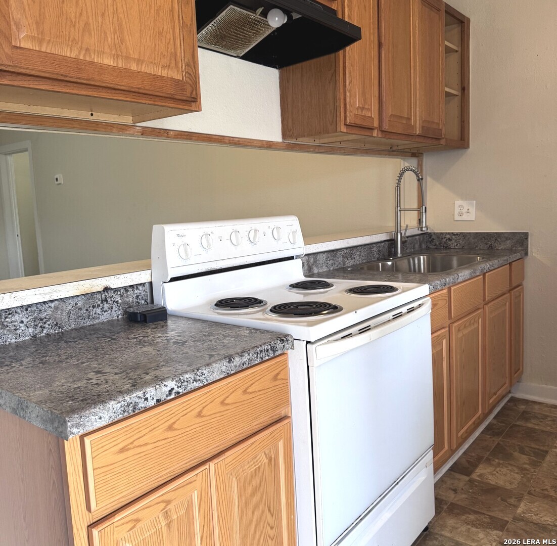 a kitchen with stainless steel appliances granite countertop a sink stove and cabinets