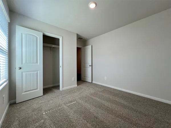 an empty room with closet and windows
