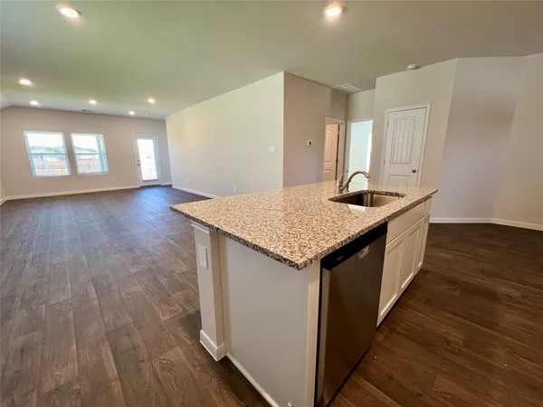 a kitchen with a sink and wooden floor