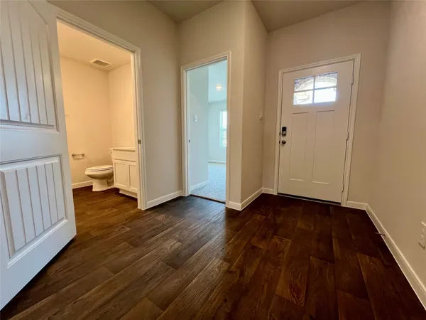 a view of a room with wooden floor and a bathroom