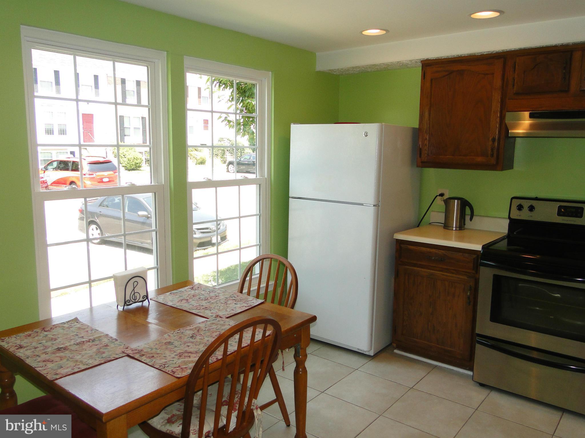 7415 Aspenpark Road Lorton, VA 22079 - Photo 6 of 17 a kitchen with a refrigerator a stove a sink dishwasher with a dining table and chair with wooden floor