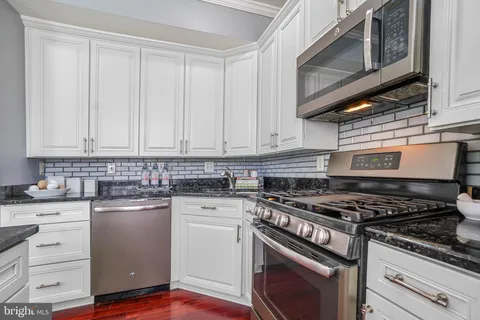 a kitchen with granite countertop cabinets stainless steel appliances and sink