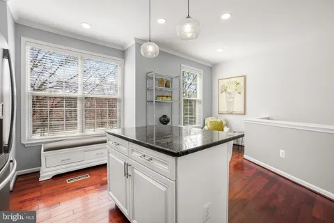 a kitchen with stainless steel appliances granite countertop a stove a sink and a refrigerator with wooden floor