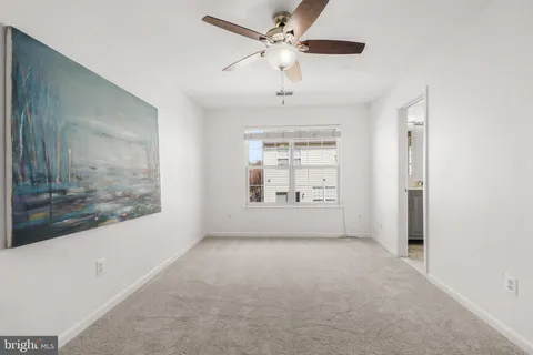 a view of a big room with windows and chandelier fan