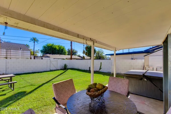 a backyard of a house with yard table and chairs
