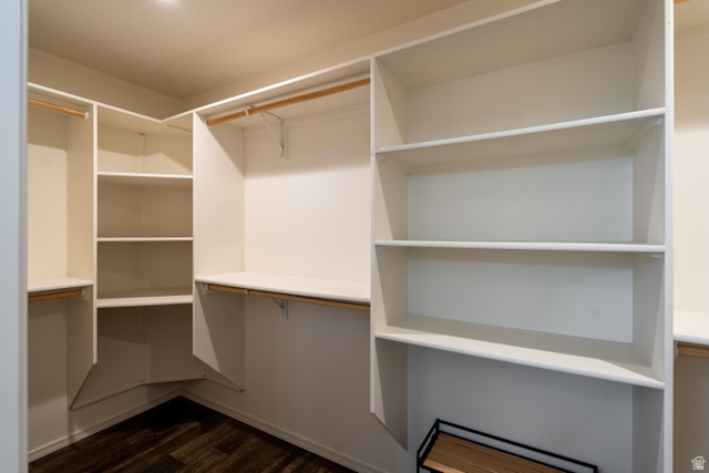 700 East Peter Springs Road Monticello, UT 84535 - Photo 25 of 57 Walk-in closet featuring built-in white shelving, multiple hanging rods, and dark wood-finish flooring