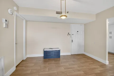 a view of an empty room with closet and a window