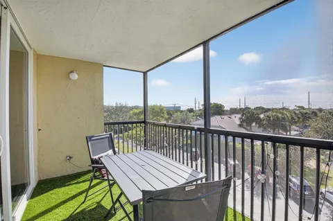 a view of a balcony with chair and wooden floor