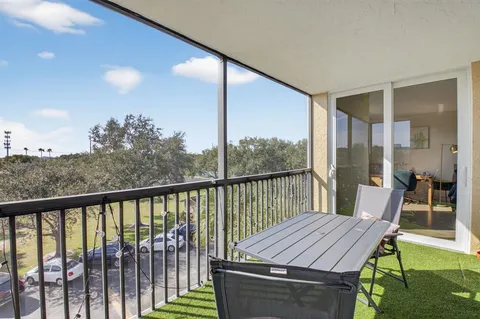 a balcony with wooden floor table and chairs