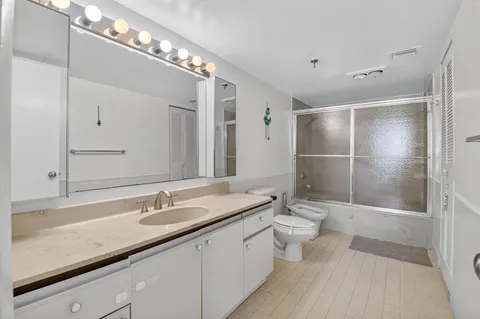 a bathroom with a double vanity sink toilet and shower