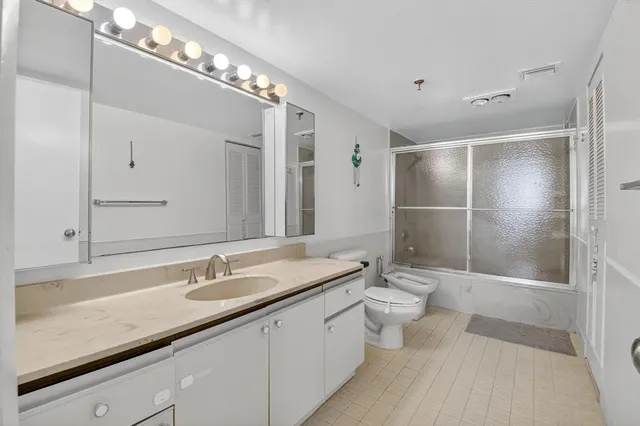 a bathroom with a double vanity sink toilet and shower