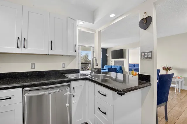 a kitchen with granite countertop a sink white cabinets and a granite counter tops