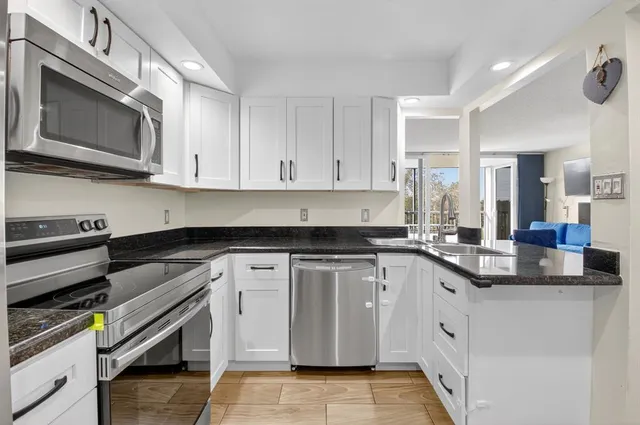 a kitchen with stainless steel appliances granite countertop a sink and a stove