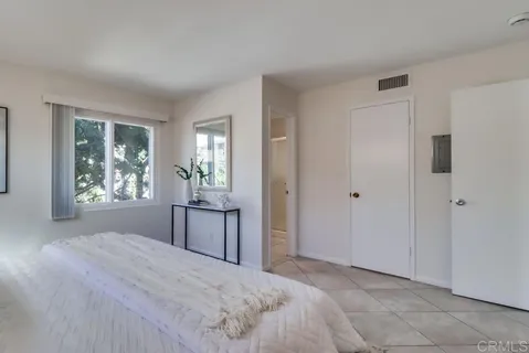 a large bedroom with a bed and a window