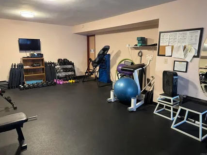 a room with gym equipment and a flat screen tv