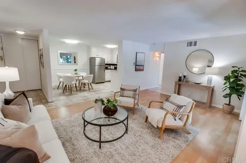 a living room with furniture potted plant and white walls